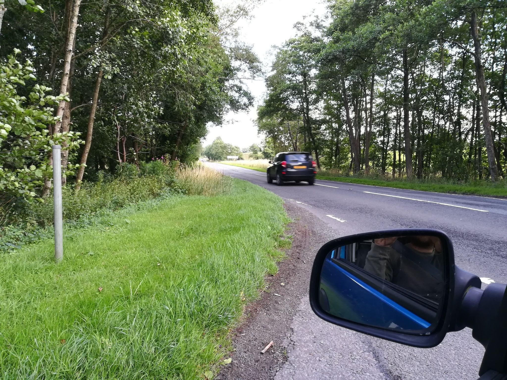 Side road turning onto the A76 showing no footway or any other accommodation for active travel