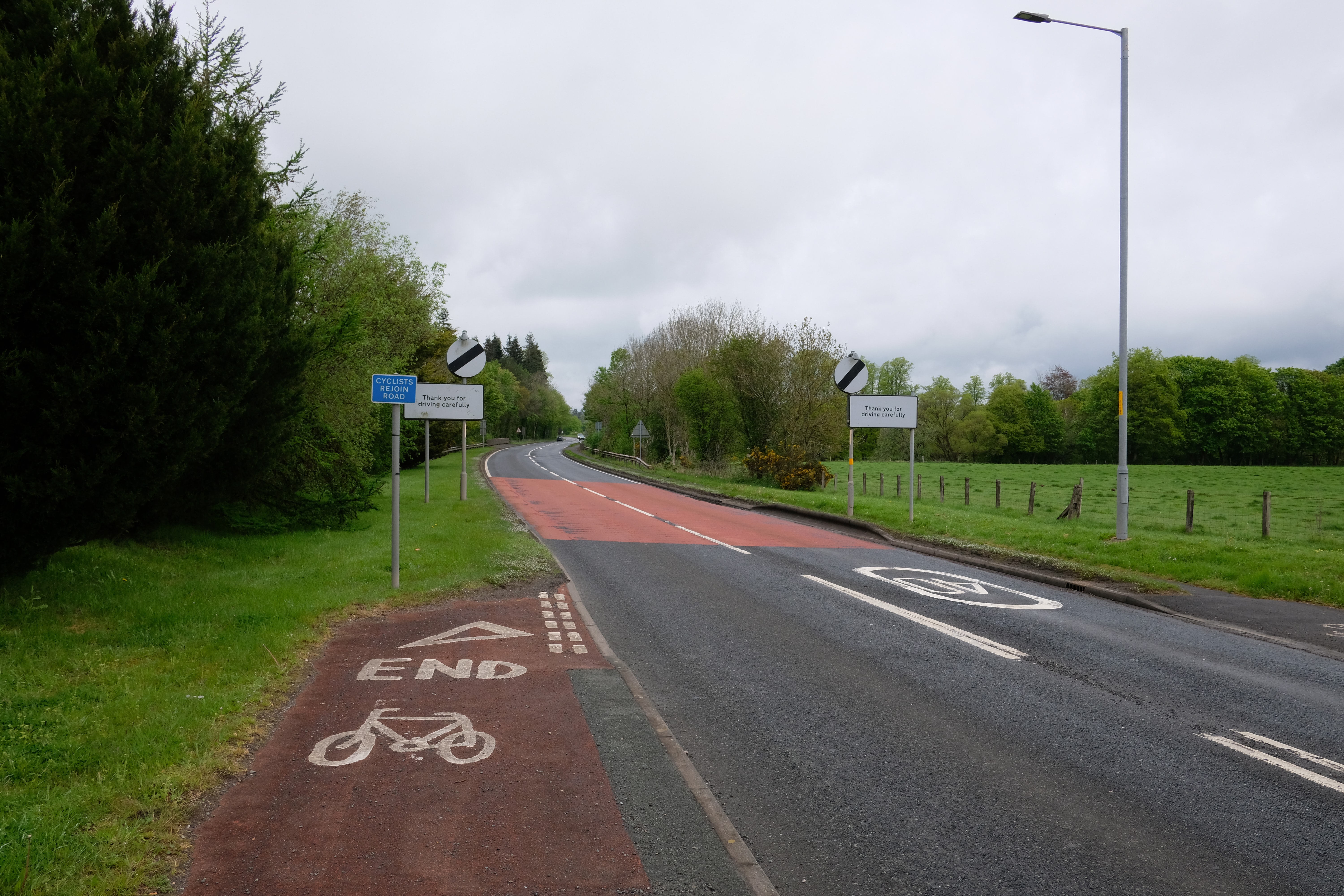 End of cycleway with Cyclists Rejoin Road sign just before the national speed limit sign